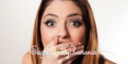 O fată drăguță surprinsă, cu mâna în gură