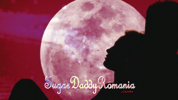 bărbat și femeie îmbrățișați și stând sub o lună roșie mare