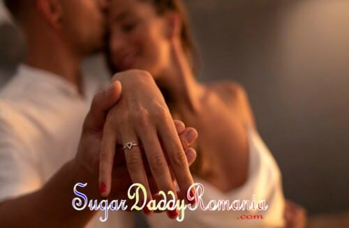 Femeia își arată verigheta în timp ce Sugar Daddy o îmbrățișează