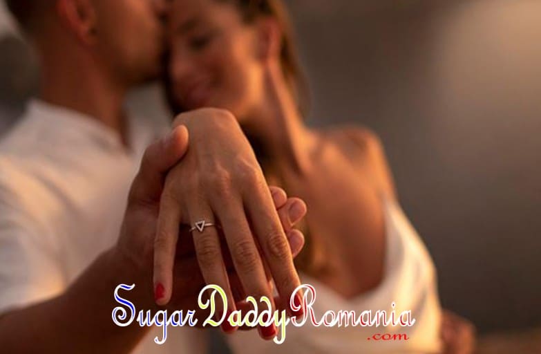 Femeia își arată verigheta în timp ce Sugar Daddy o îmbrățișează